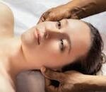 A calming spa massage session with a young woman receiving a relaxing head massage.